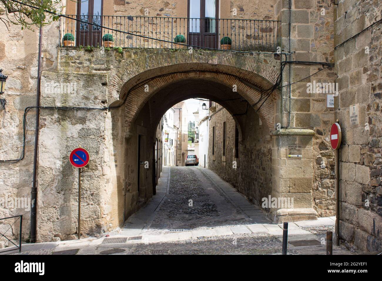 Caceres, Spagna. La Puerta de Coria (porta Coria), una strada con un arco nella Città Vecchia Monumentale, un sito Patrimonio dell'Umanità Foto Stock