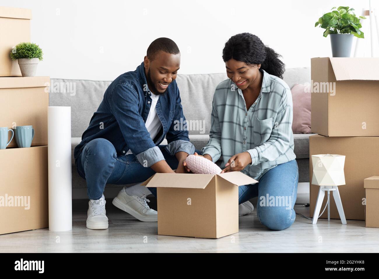 Happy African American coniugi Disimballo scatole di cartone con oggetti personali a New Flat Foto Stock