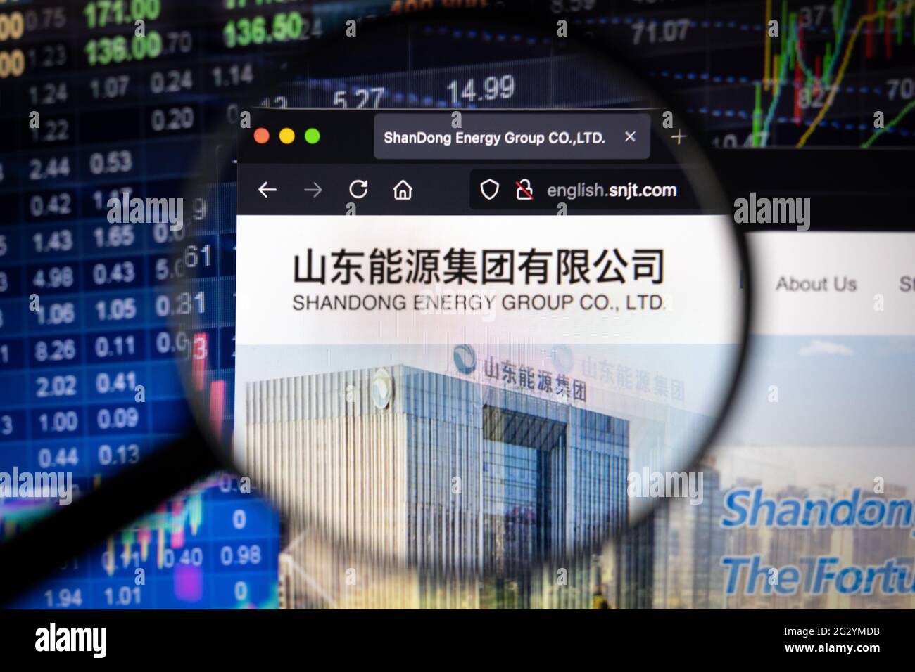 Shandong Energy logo aziendale su un sito web con sviluppi del mercato azionario sfocato in background, visto su uno schermo del computer Foto Stock