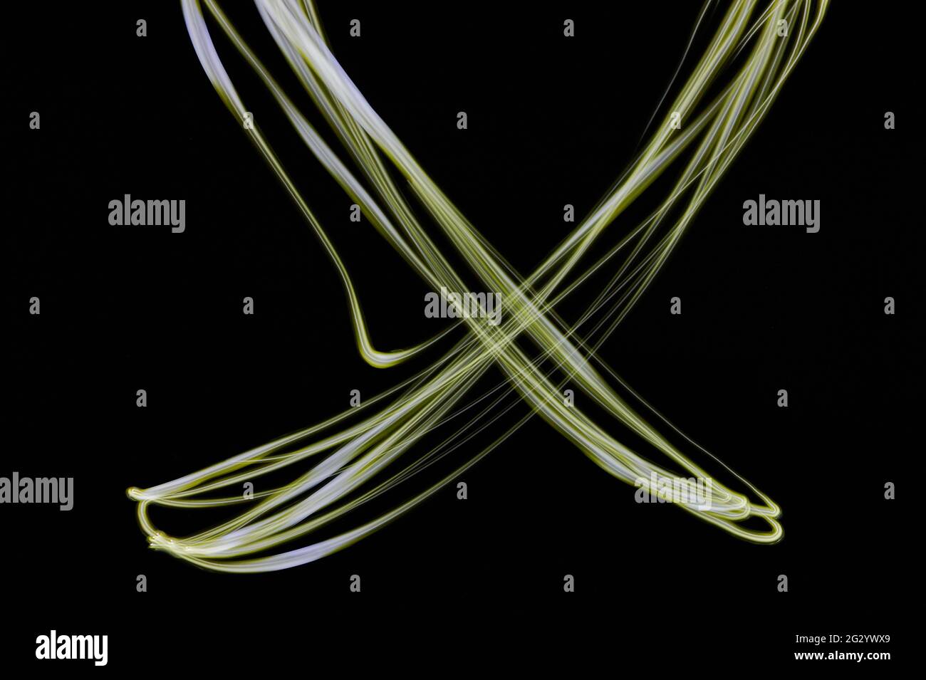 Luce al neon giallo incrociato isolata su sfondo nero Foto Stock