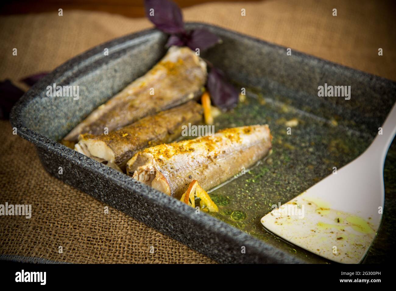 pesce cotto al forno con spezie, spezie su una teglia Foto Stock