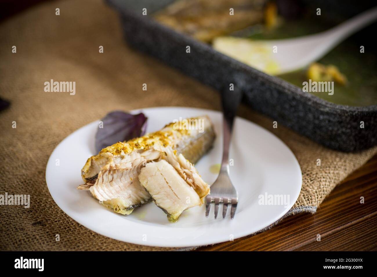 pesce cotto al forno con spezie, spezie in un piatto Foto Stock