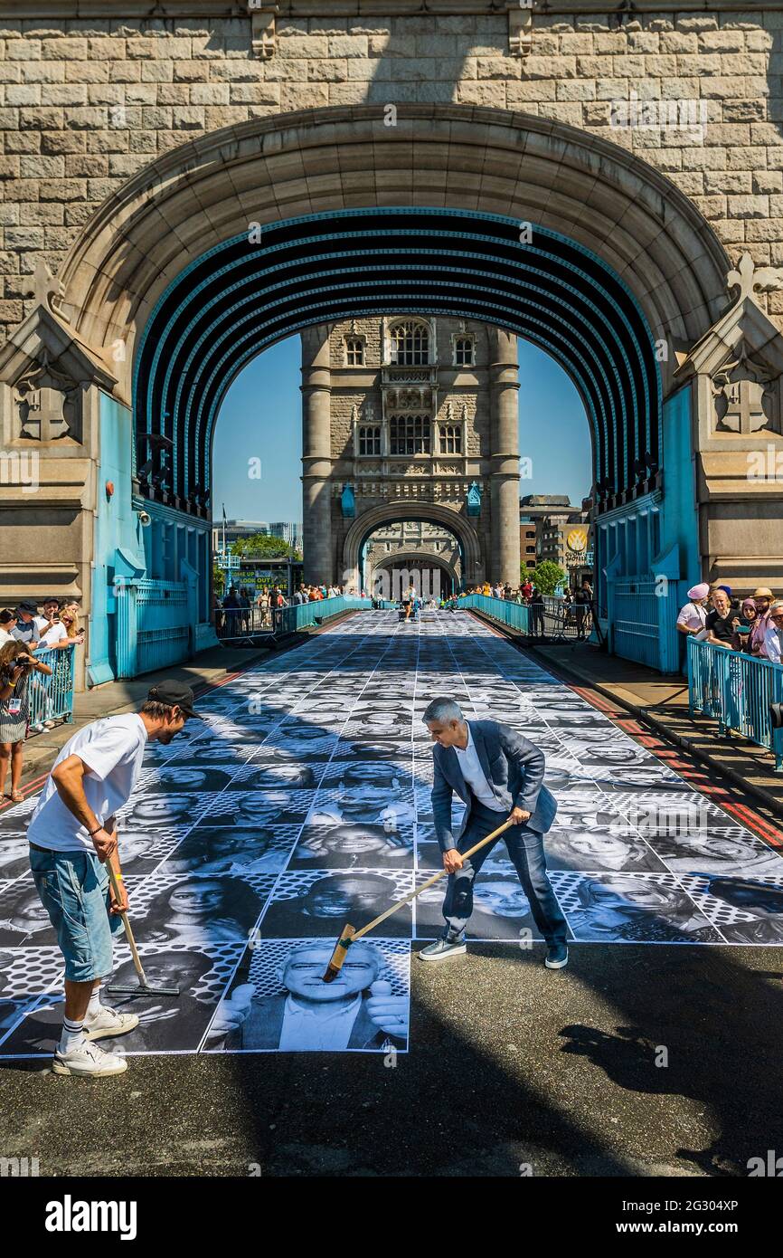 Londra, Regno Unito. 13 giu 2021. Sadiq Khan (nella foto che mette la sua foto sul ponte) visita il Tower Bridge mentre viene incollato con più di 3,000 fotografie di ritratto in bianco e nero in occasione dei Campionati di calcio UEFA EURO 2020. All'interno fuori è la celebrazione culturale della capitale del calcio e la sua capacità di riunire le persone. Credit: Guy Bell/Alamy Live News Foto Stock