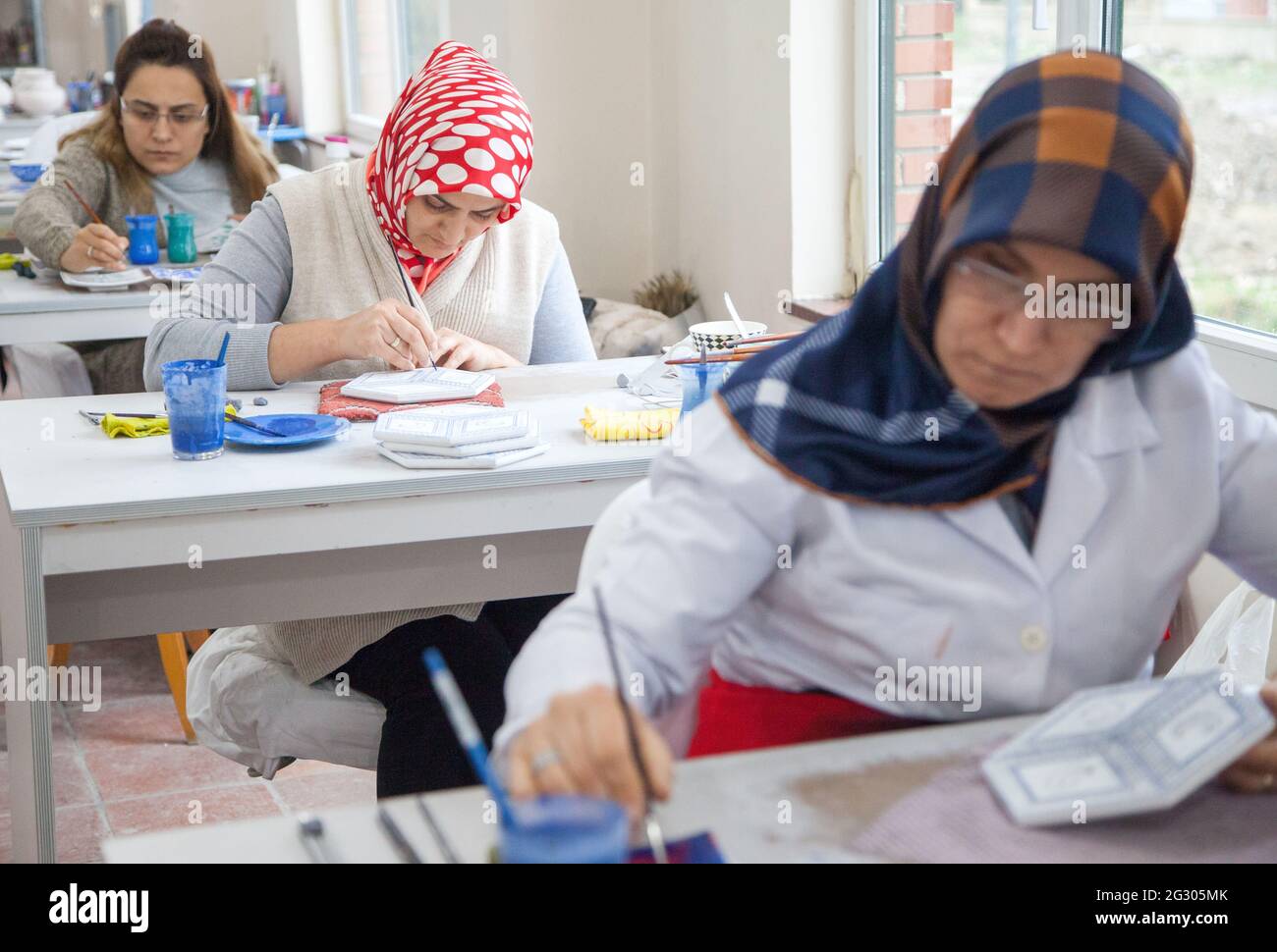 Cini art. Tegola turca artista femminile di piastrelle dipinge porcellana in officina. Iznik, Turchia - 12/29/2016 Foto Stock