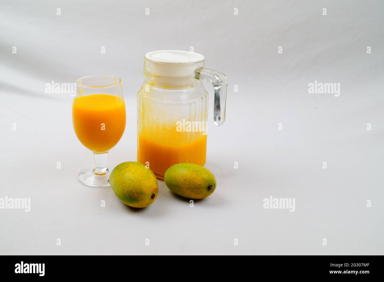 Un colpo ad alto angolo di mango, una caraffa e un bicchiere di succo di mango fresco Foto Stock