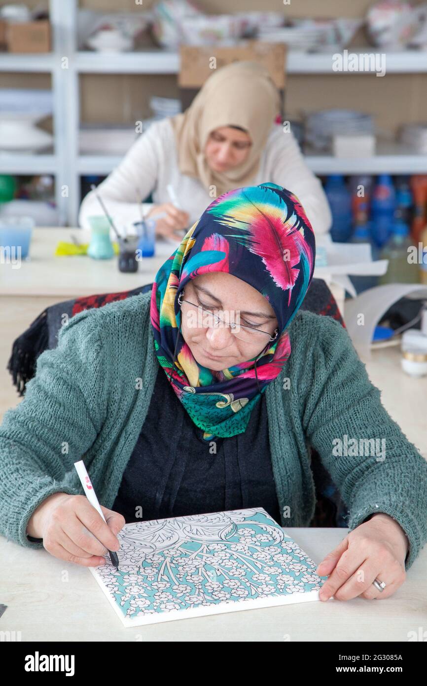 Cini art. Tegola turca artista femminile di piastrelle dipinge porcellana in officina. Iznik, Turchia - 12/29/2016: Foto Stock