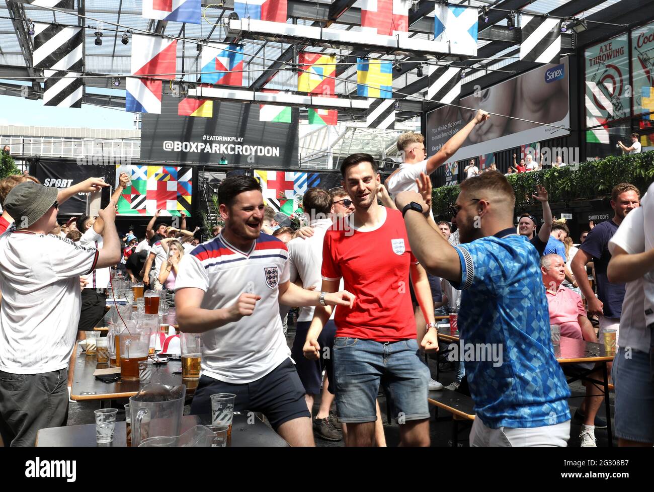 I fan celebrano il primo gol della partita in Inghilterra, segnato da Raheem Sterling (non raffigurato) al BOXPARK di Croydon mentre guardano la partita UEFA Euro 2020 del gruppo D tra Inghilterra e Croazia tenutasi allo stadio di Wembley. Data immagine: Domenica 13 giugno 2021. Foto Stock