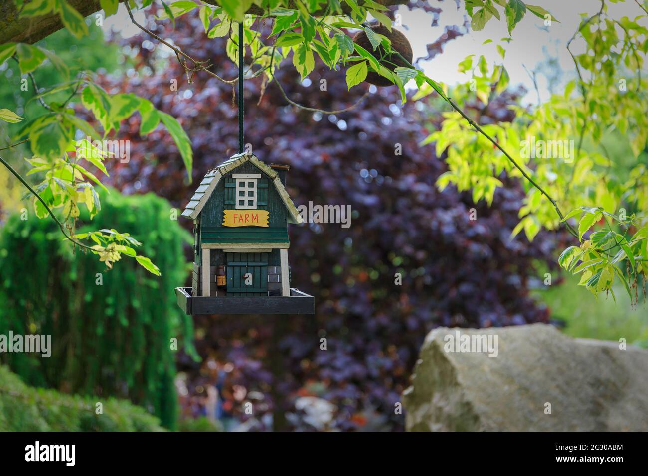 Appendere la casa degli uccelli in legno nel giardino dello zoo Foto Stock