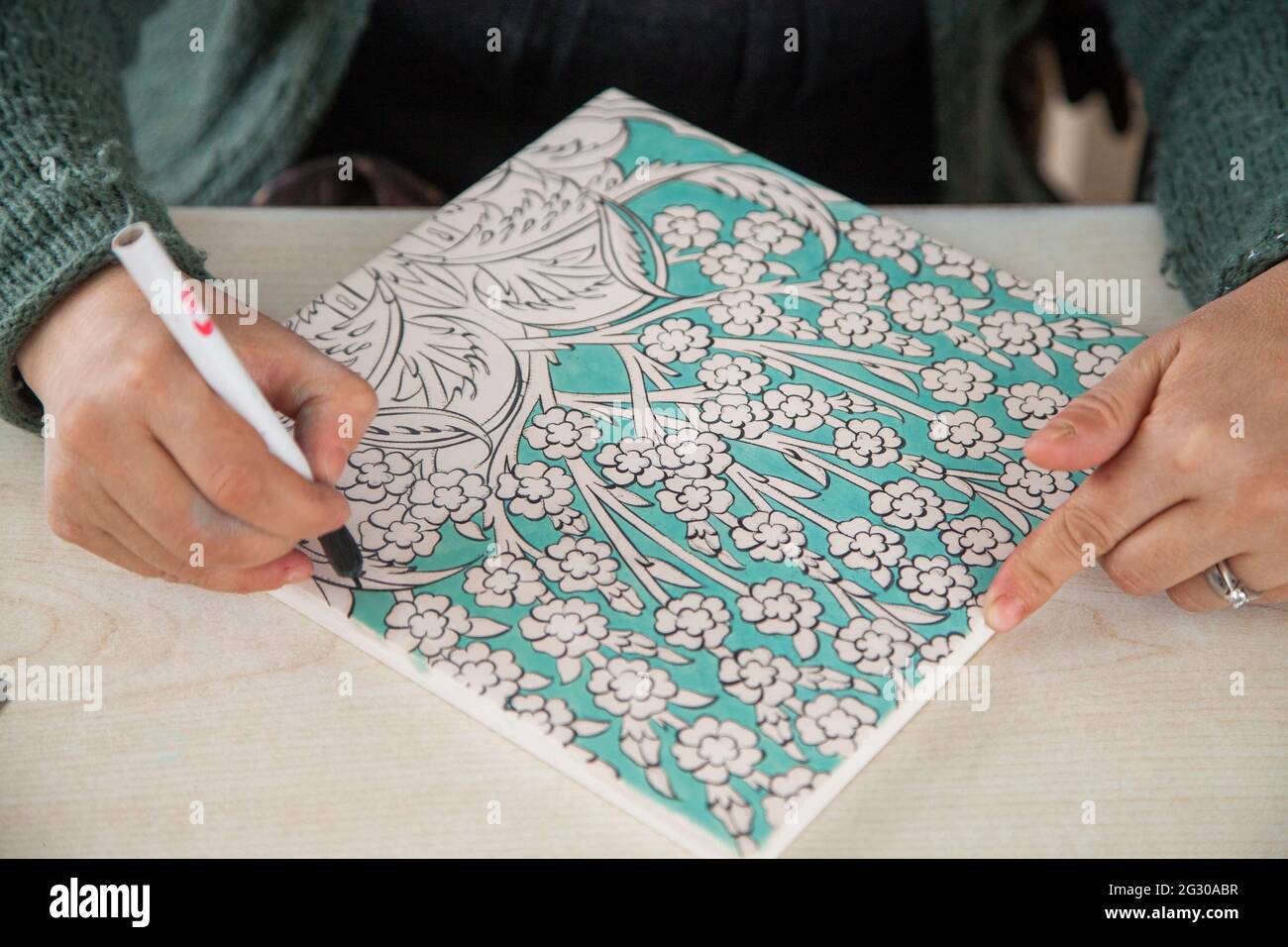 Cini art. Tegola turca artista femminile di piastrelle dipinge porcellana in officina. Iznik, Turchia - 12/29/2016 Foto Stock