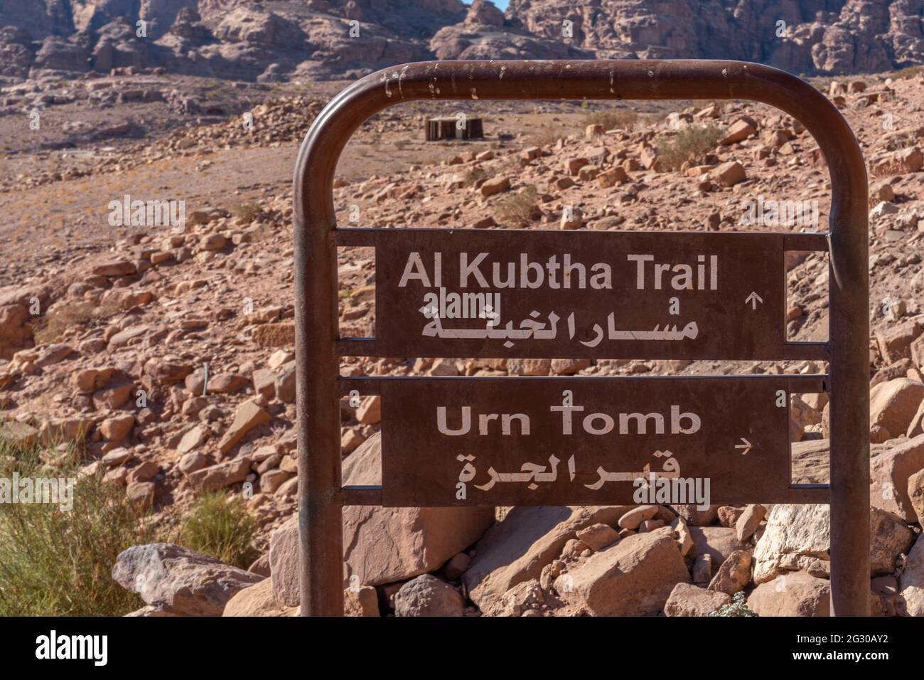 Segno direzionale in inglese e arabo al sentiero al-kubtha e tomba urna, petra, giordania Foto Stock