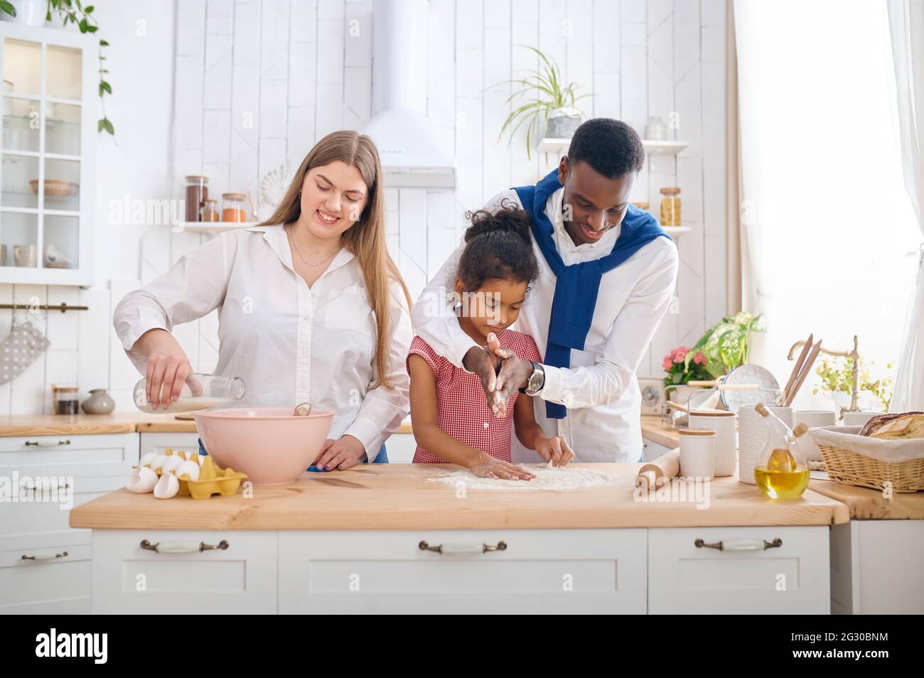 Buona famiglia che cucinano torte a colazione in cucina Foto Stock