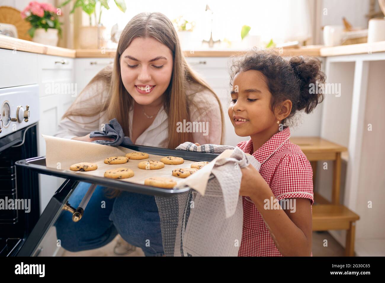 Madre e capretto cucinano torte nel forno a colazione Foto Stock
