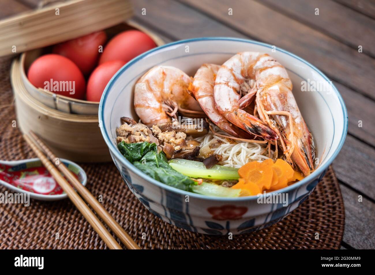 Primo piano su servire di noodle longevità di compleanno con uova rosse, una tradizione tra i cinesi durante le celebrazioni di compleanno Foto Stock