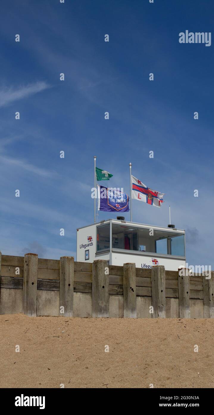 Stazione di bagnino RNLI che tiene la guardia sulla spiaggia di West Bay Beach, Jurassic Coast, Dorset, Inghilterra, con spazio di copia Foto Stock