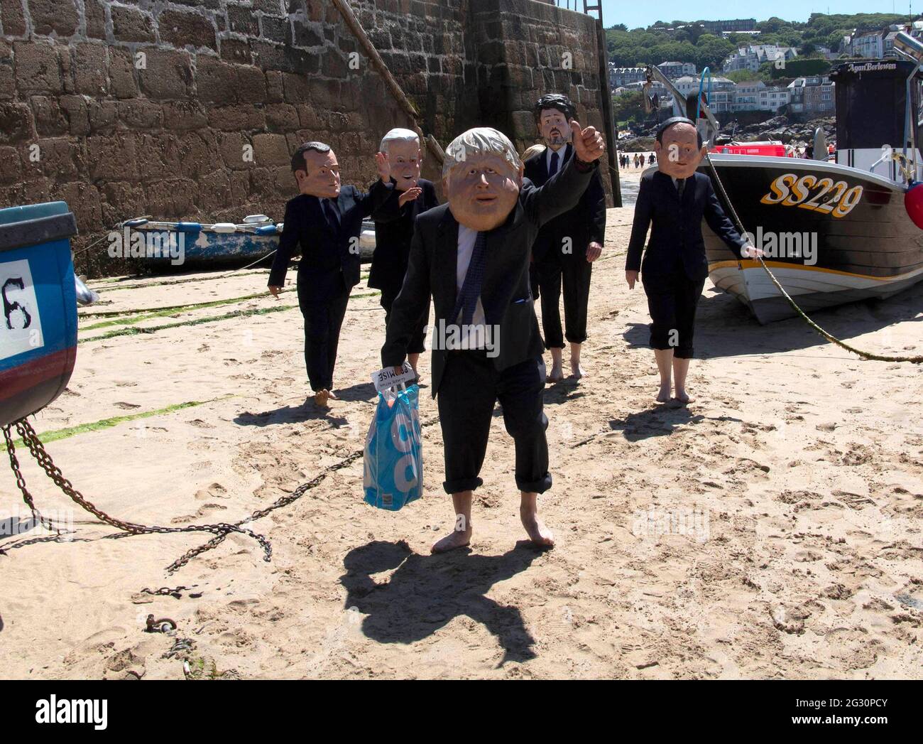 St Ives, Cornovaglia, Regno Unito. 13 giugno 2021. I membri di Extinction Rebellion vestono come membri del G7 come una prestazione caratterizzata, criticando la mancanza di azione climatica. Gli attori si uniscono alla protesta sul porto di St Ives, in Cornovaglia, l'ultimo giorno del vertice del G7. 13 giugno 2021. Anna Hatfield/ Pathos Credit: One Up Top immagini editoriali/Alamy Live News Foto Stock