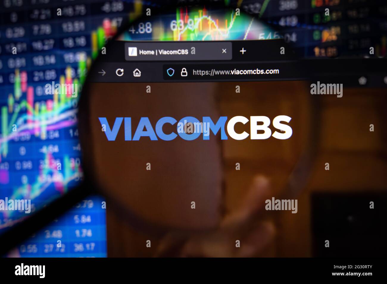 Logo di Viacom CBS Company su un sito web con sviluppi di mercato azionario sfocato in background, visto su uno schermo del computer attraverso una lente di ingrandimento Foto Stock