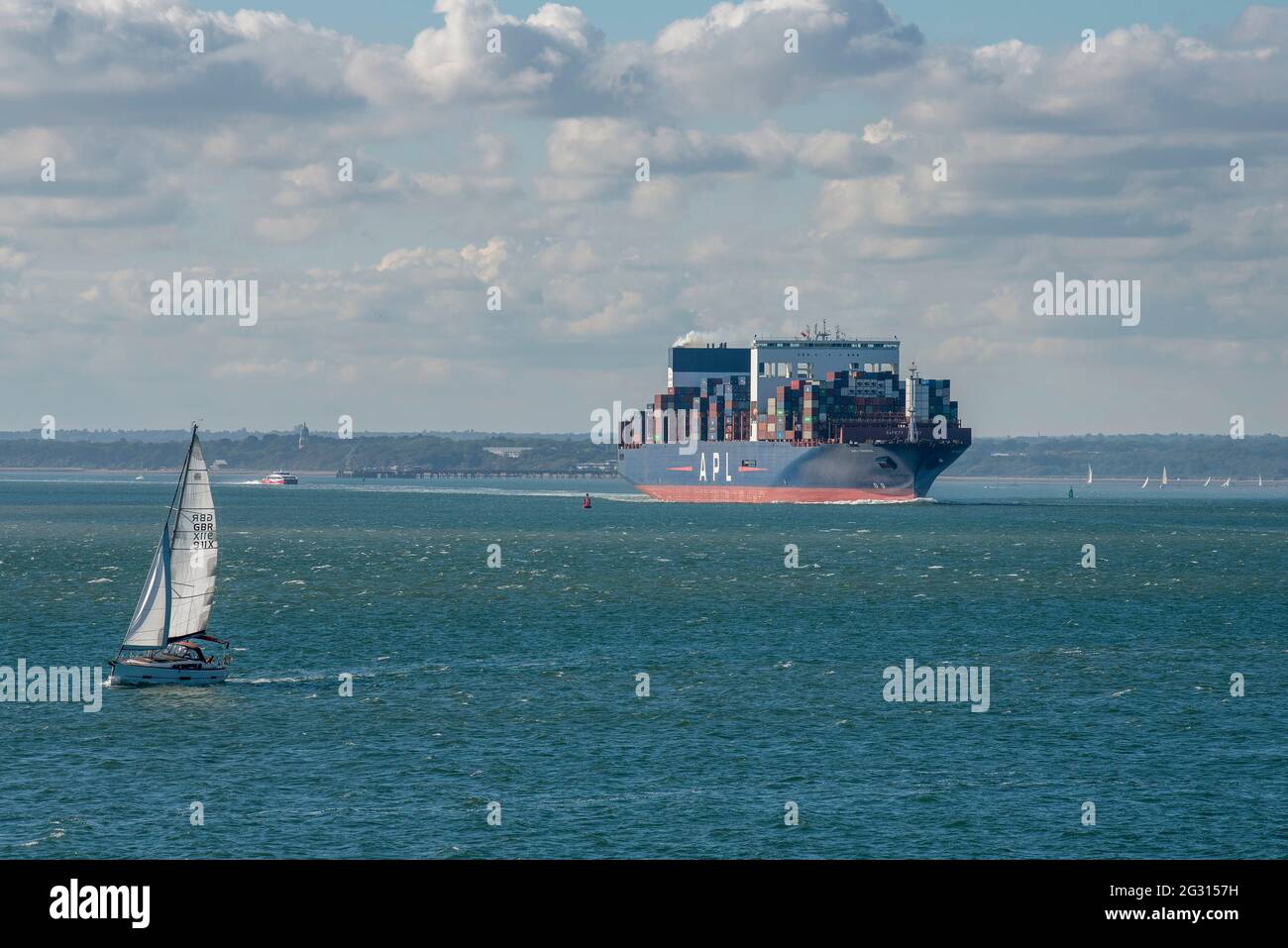 Southampton Water, Inghilterra, Regno Unito. 2021. La nave portacontainer APL Vanda è in corso in direzione sud su Southampton Water in avvicinamento ad un piccolo yacht. Foto Stock