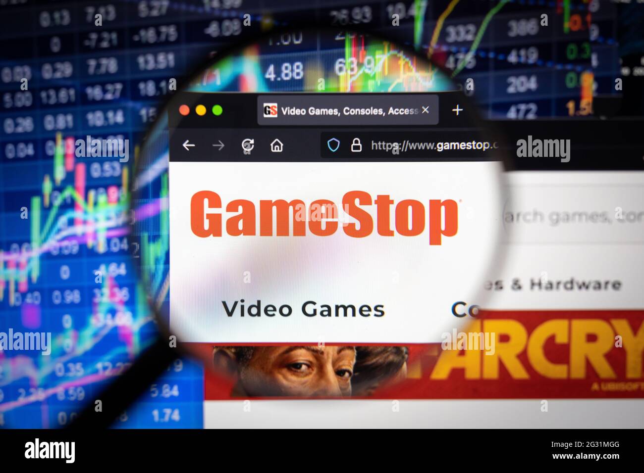 Logo della società Gamestop su un sito web con sviluppi sfocati del mercato azionario in background, visto su uno schermo del computer attraverso una lente di ingrandimento Foto Stock