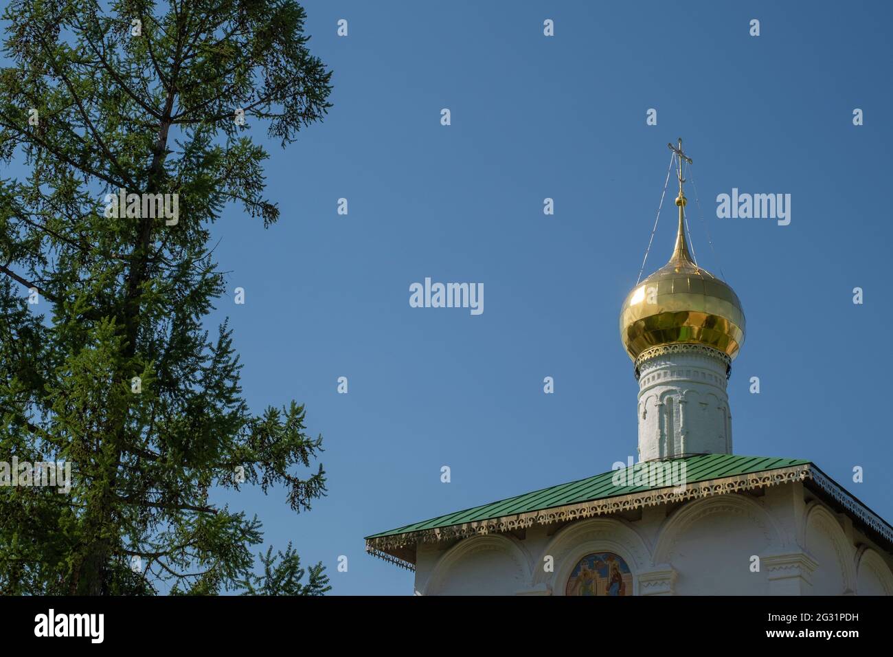Cupola dorata con una croce sullo sfondo di un cielo blu senza nuvole nel monastero di Borisoglebsky, regione di Yaroslavl, Russia. Foto Stock