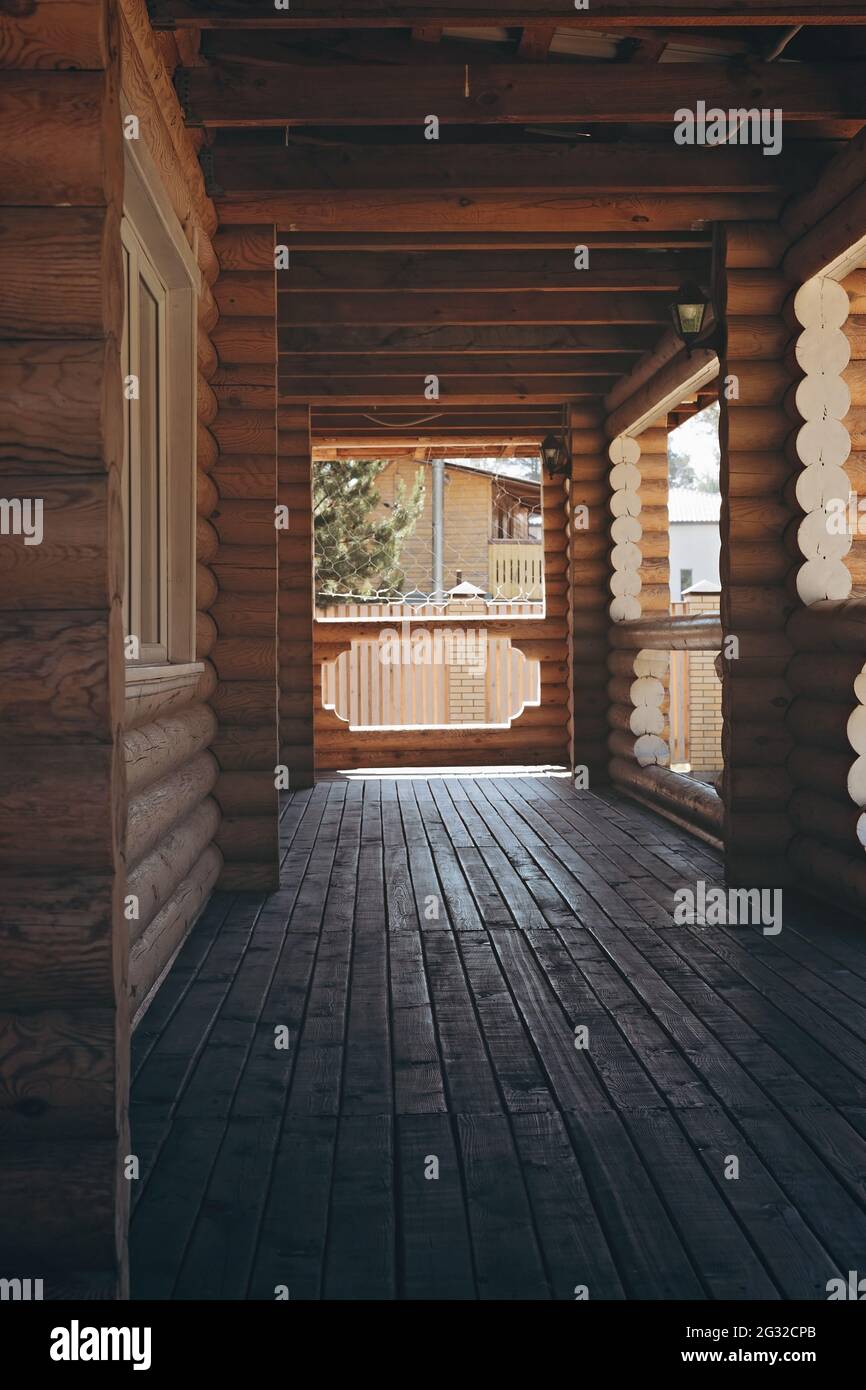 Terrazza aperta di una casa in legno. Riposo e relax in campagna nella natura in estate. Una casa fatta di un solido log rotondo. Costrutto suburbano Foto Stock