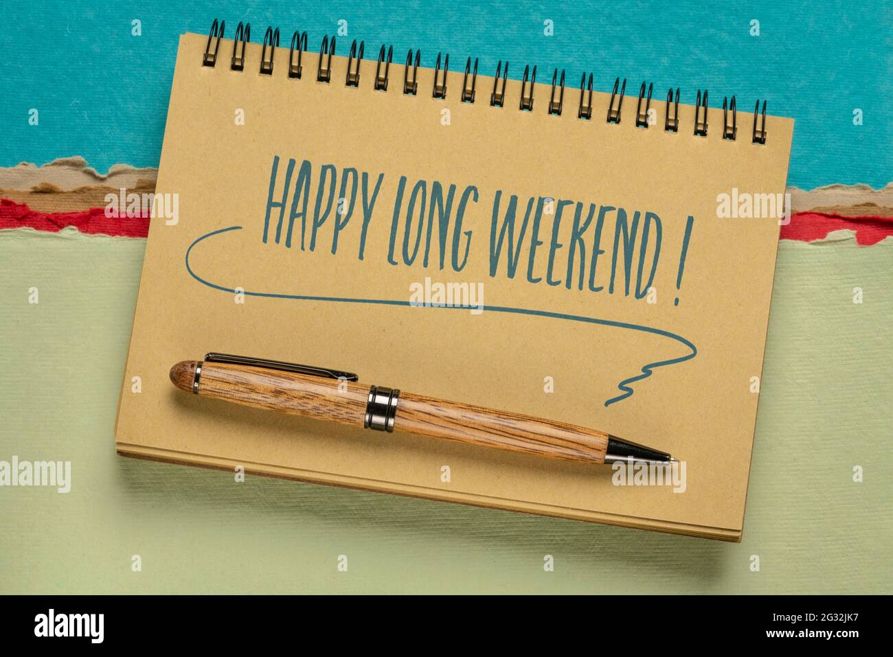 Buon fine settimana lungo - scrittura a mano in un notebook a spirale contro colorato paesaggio di carta astratta Foto Stock
