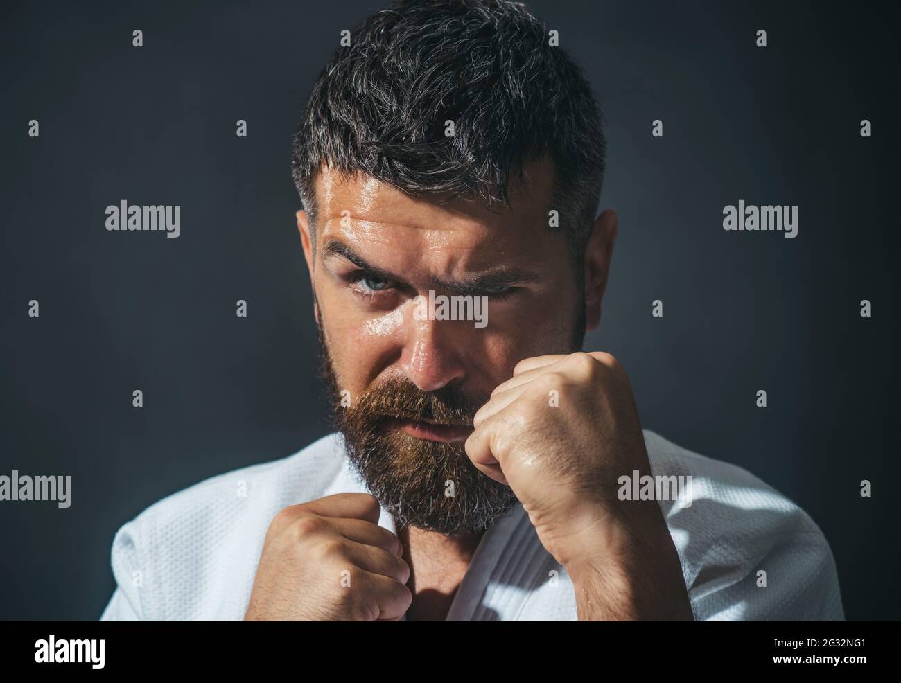 Karate uomo in kimono nella posizione di combattimento. Il maschio bearded fa l'addestramento del karate Foto Stock