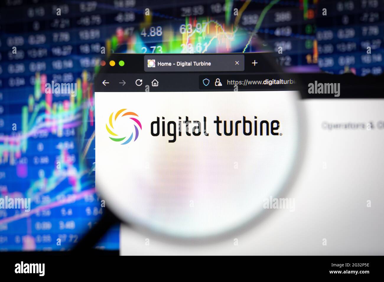 Logo della società di turbine digitali su un sito web con sviluppi poco nitidi del mercato azionario in background, visto su uno schermo del computer Foto Stock