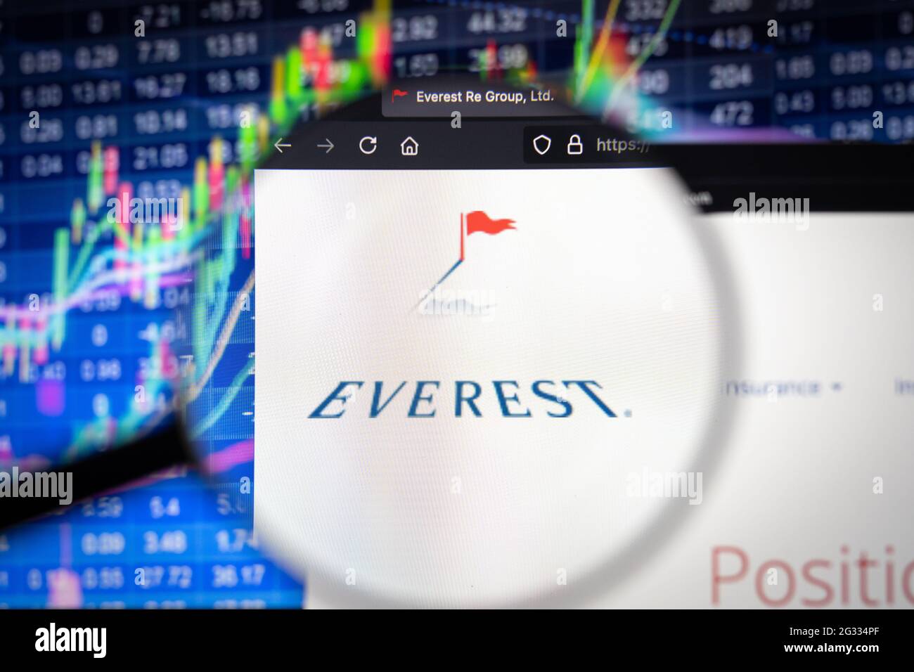 Everest logo aziendale su un sito web con sviluppi sfocati del mercato azionario in background, visto su uno schermo del computer attraverso una lente di ingrandimento Foto Stock
