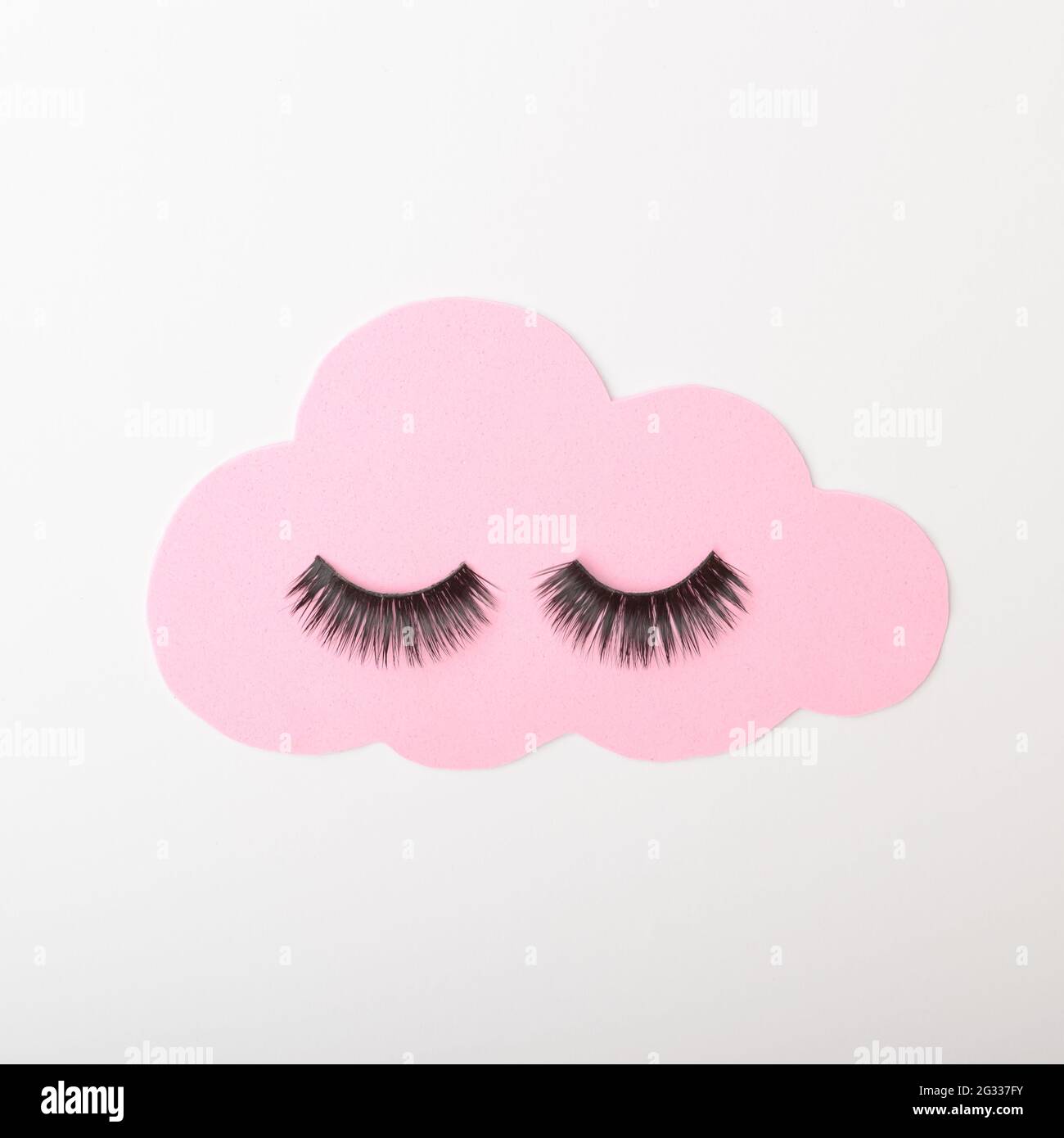 Una nuvola rosa pastello con ciglia nere su uno sfondo bianco. Cloud CONNECT STILL LIFE Inspiration. Telaio piatto. Foto Stock