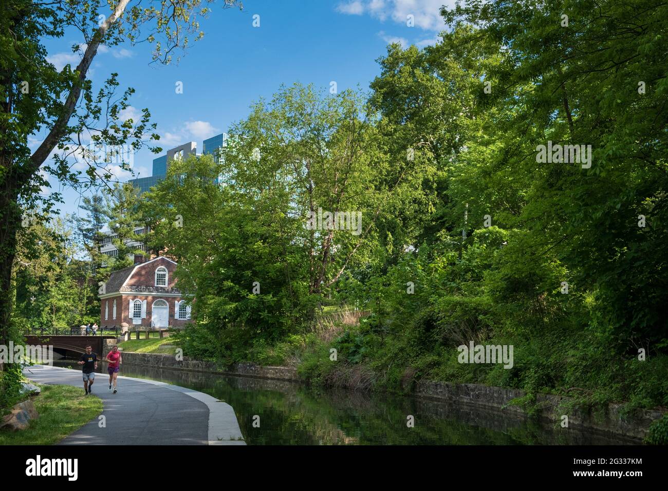 Persone sul sentiero nel Brandywine Park lungo il fiume Brandywine con la prima chiesa presbiteriana istoirica e skyline, Wilmington, Delaware, USA Foto Stock