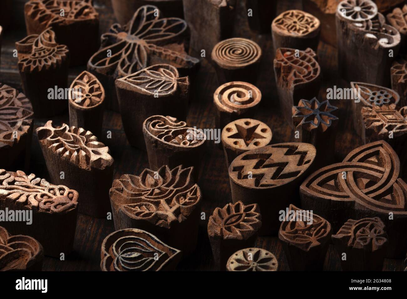 Misto tradizionale legno indiano modello a blocchi per la stampa tessile su sfondo rustico legno. Stampa a blocchi, Stampa a blocchi Rajasthan India, blocco legno Foto Stock