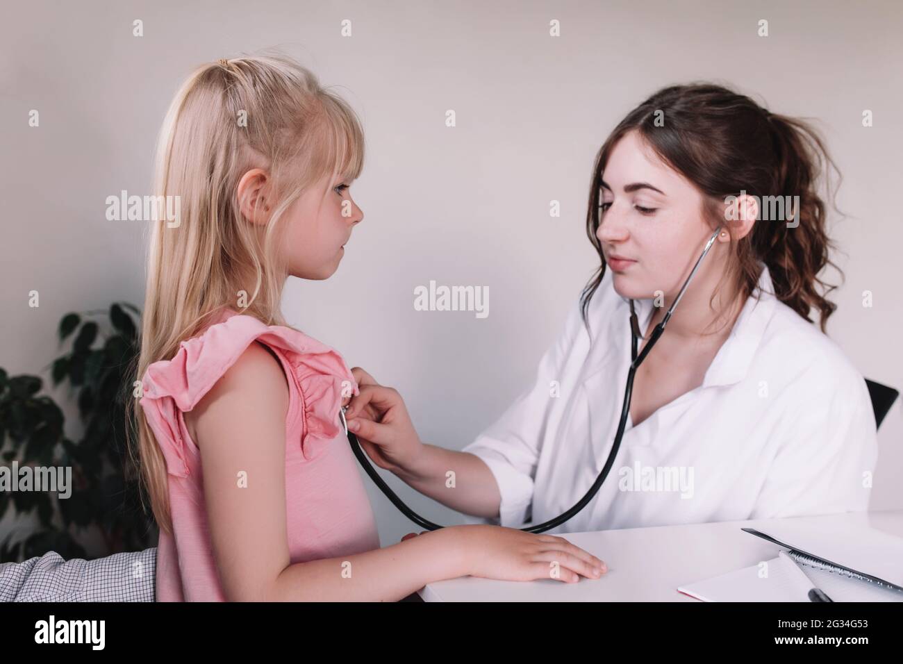 Medico o infermiere in uniforme bianca che esamina e ascolta la bambina che  usa lo stetoscopio in clinica durante la visita del medico. Foto di alta  qualità Foto stock - Alamy