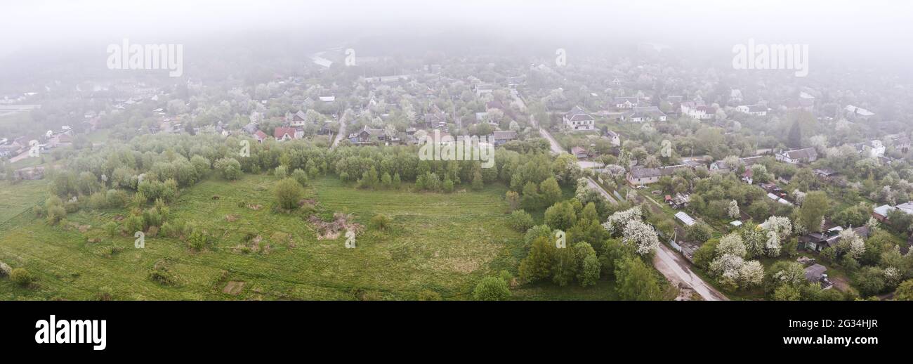 Paesaggio urbano aereo di quartieri residenziali e sobborghi della città di Minsk, Bielorussia, in una giornata estiva nebbiosa Foto Stock