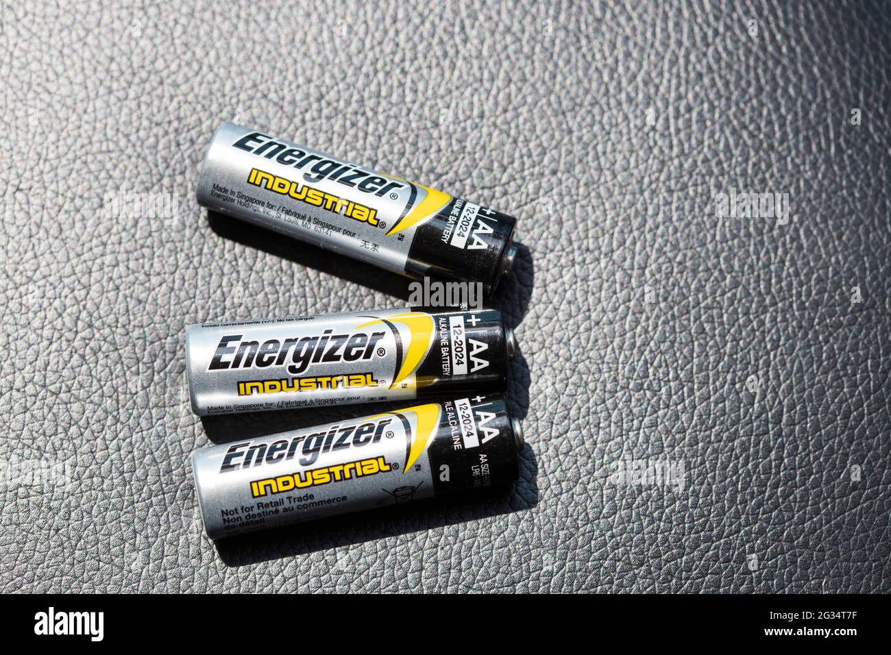 HAMILTON, Ontario, Canada - Giugno 2021: Tre batterie AA Energizer sono stese su una superficie nera testurizzata. Foto Stock