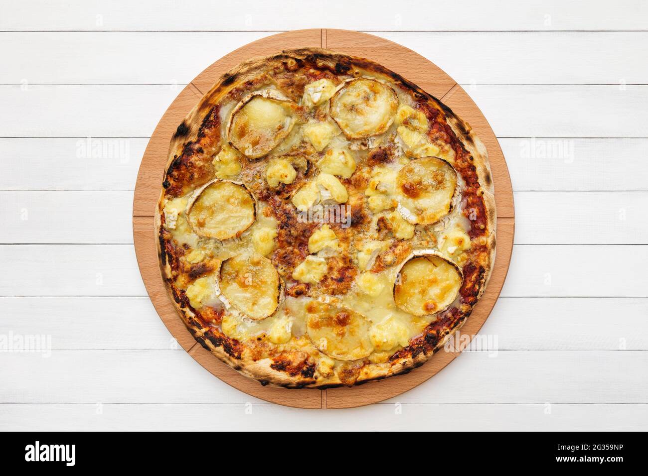 Pizza al formaggio di capra su piatto di legno. Vista dall'alto sullo sfondo della lavagna bianca Foto Stock