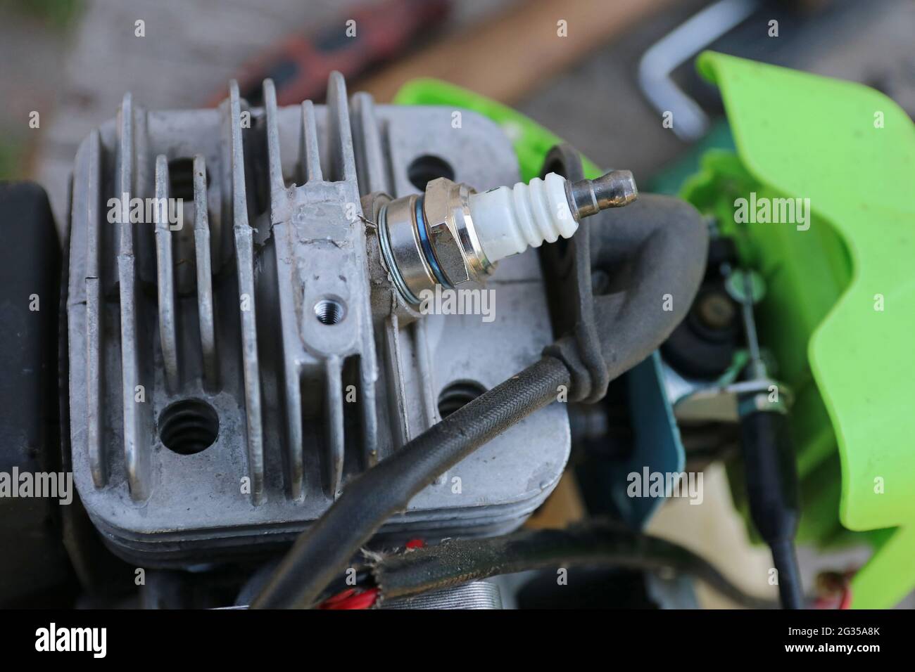 Motore trimmer benzina. Candela nella testata del motore. Foto Stock