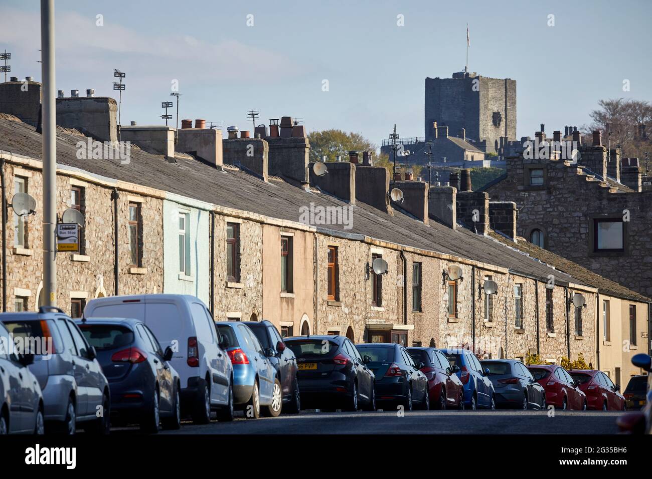 Clitheroe Castle ha parcheggiato le auto di fronte a case a schiera in pietra lungo Whalley Road, Ribble Valley in Lancashire Foto Stock