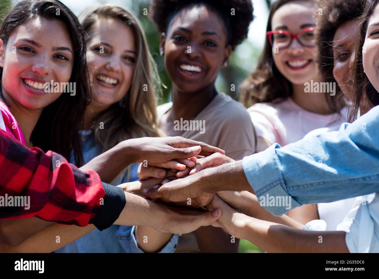 Gruppo di giovani adulti internazionali soggiornano insieme all'aperto in estate in città Foto Stock