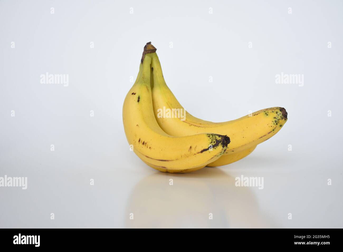 Banane mature gialle su fondo bianco isolato Foto Stock