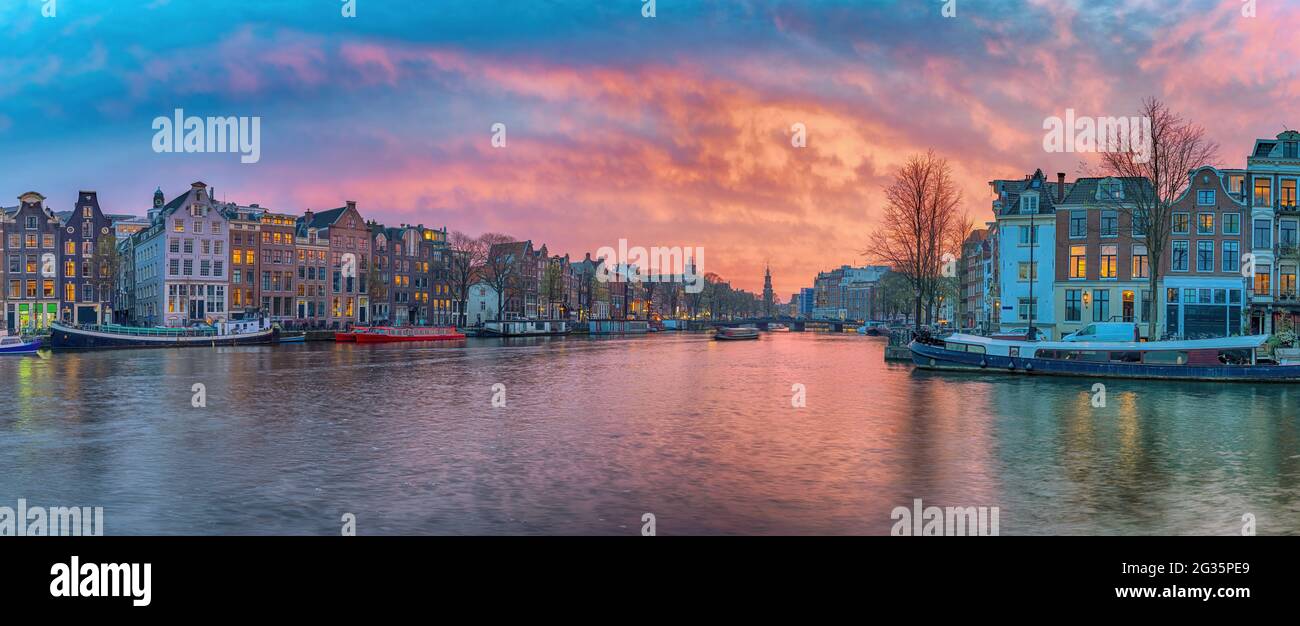 Amsterdam Paesi Bassi, panorama tramonto skyline della città di casa olandese sul canale lungomare Foto Stock