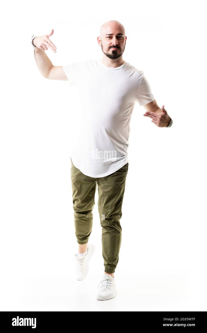 Giovane elegante moderno uomo calvo alla moda piegandosi e puntando a sé con copyspace. Lunghezza totale del corpo isolata su sfondo bianco Foto Stock