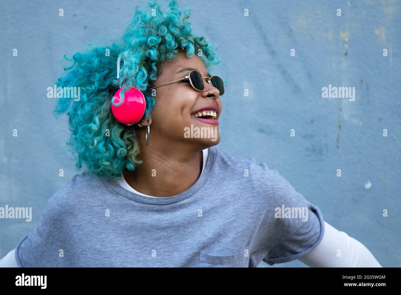 donna afro americana nera con cuffie per strada sorridente felice Foto Stock