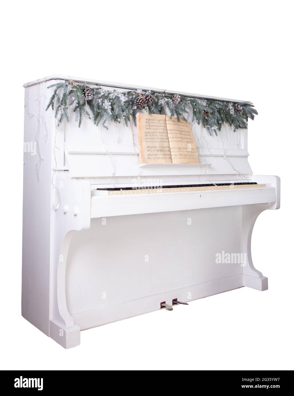 Piano bianco isolato su sfondo bianco. Rami di abete rosso e garland. Decorazione di Natale. I tasti del piano retrò sono aperti. Strumento musicale. Foto Stock