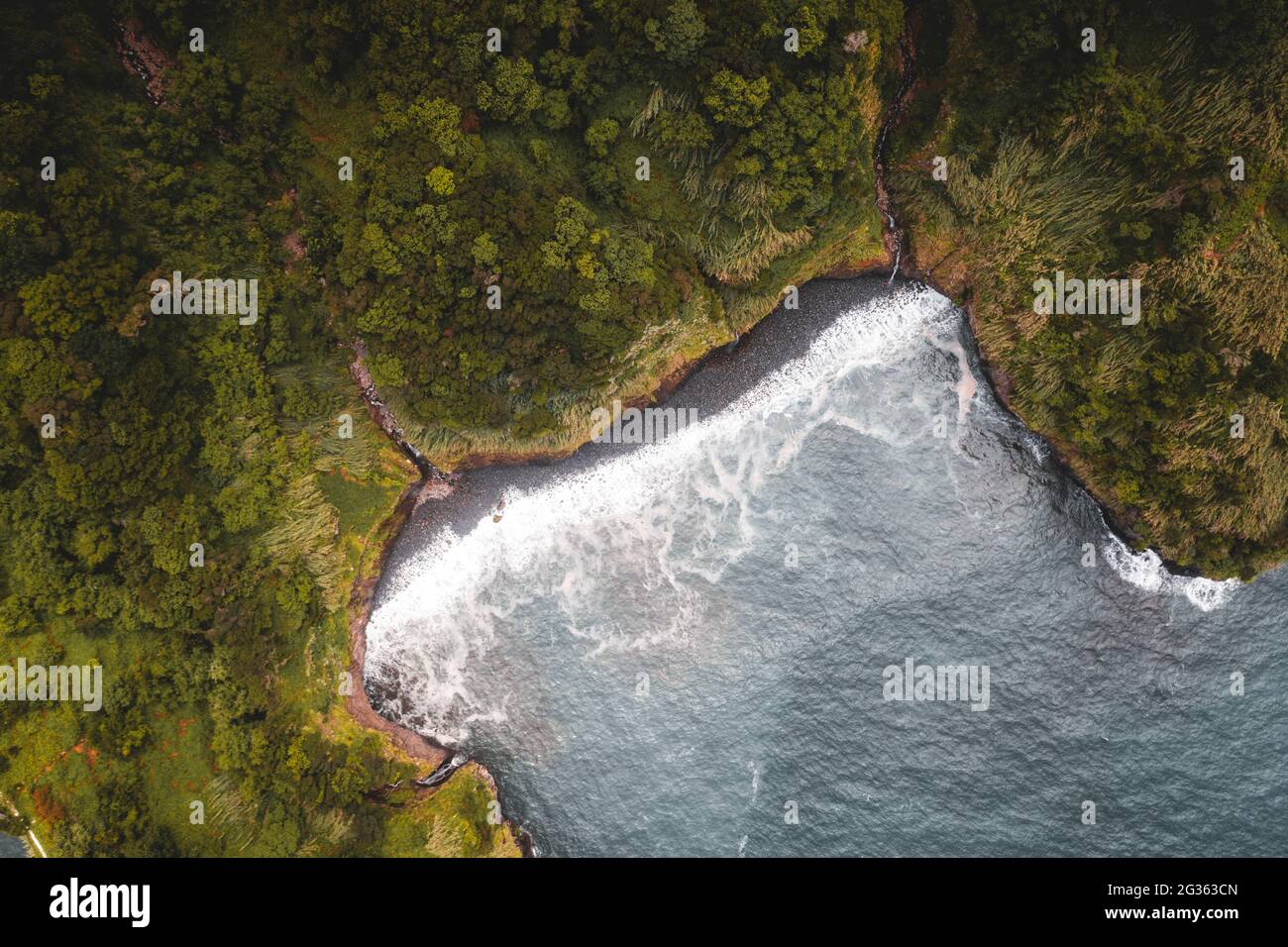 Onde che si infrangono sulla spiaggia di sabbia nera vulcanica dall'alto, Seixal, Madeira, Portogallo Foto Stock
