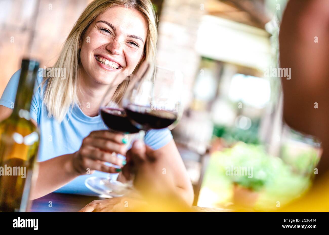 Raccolto inclinato di felice coppia che tostano vino rosso al ristorante di campagna - concetto di vita di cibo e bevande con fidanzato e fidanzata Foto Stock