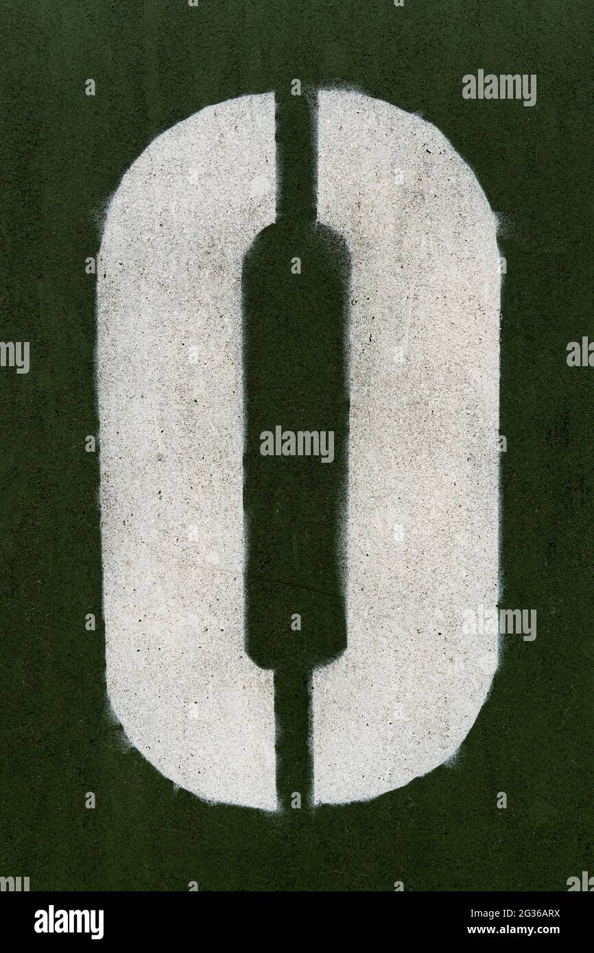 Numero zero spruzzato su una superficie verde scuro Foto Stock