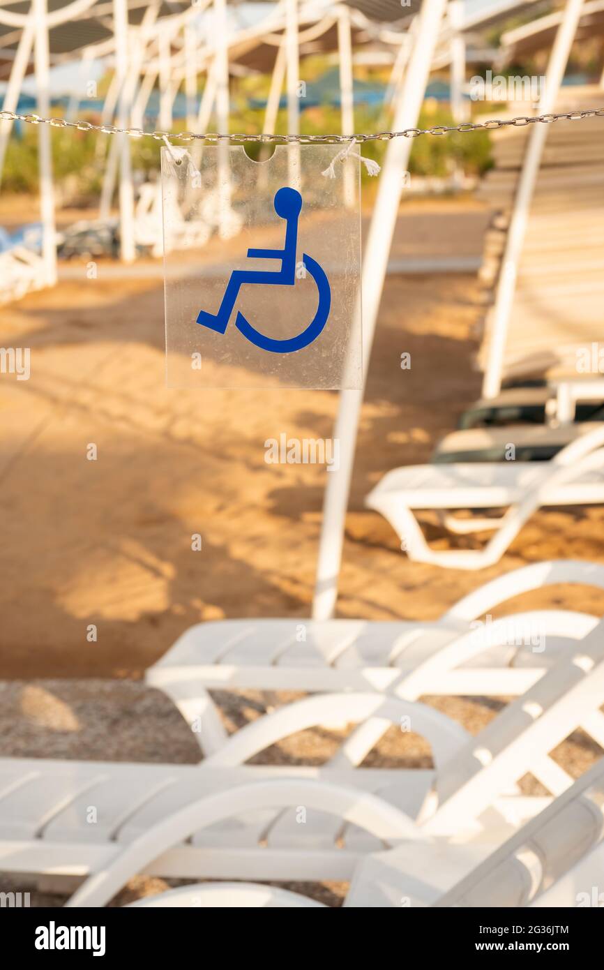 Cartello per sedie a rotelle che mostra i lettini riservati ai disabili. Lettini per sedie a rotelle riservati in spiaggia ad Antalya, Turchia. Foto Stock