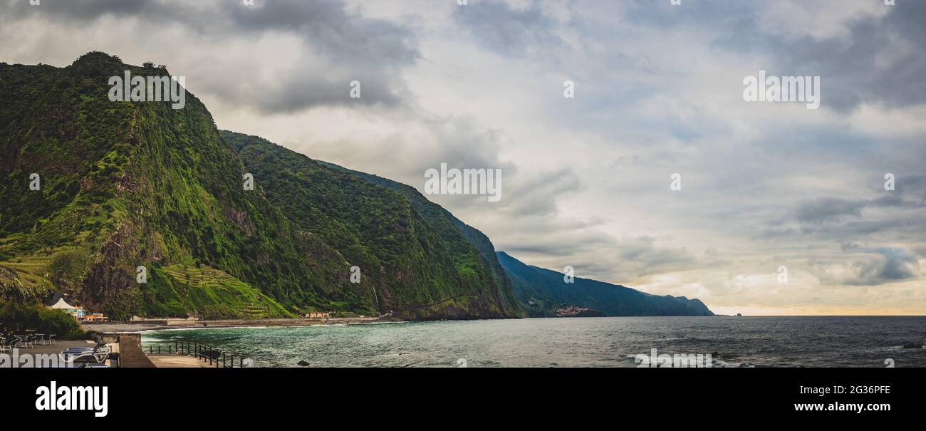 Scogliere e montagne boscose sulla costa di un mare Foto Stock
