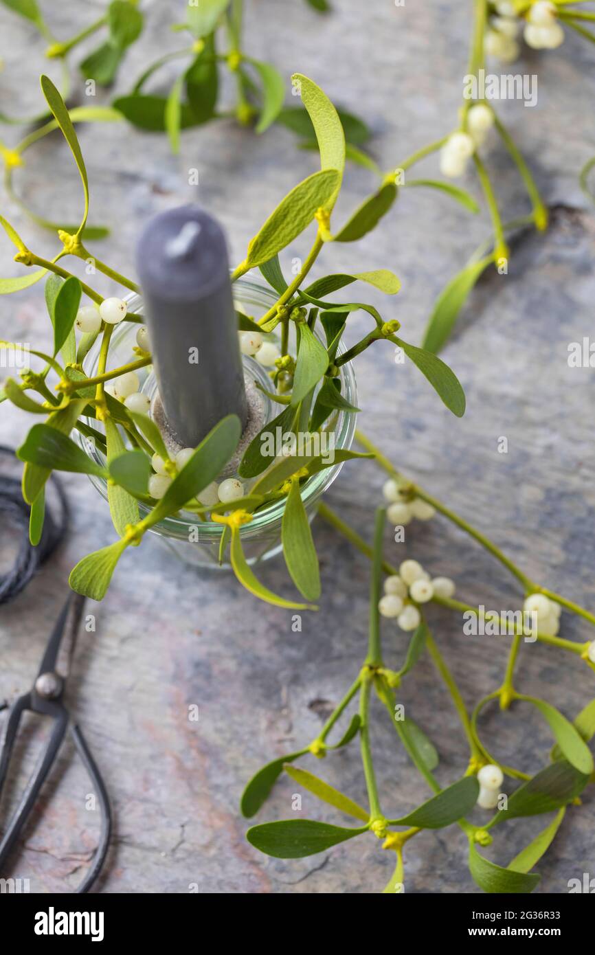 candela con mistletoe come decorazione della tabella Foto Stock