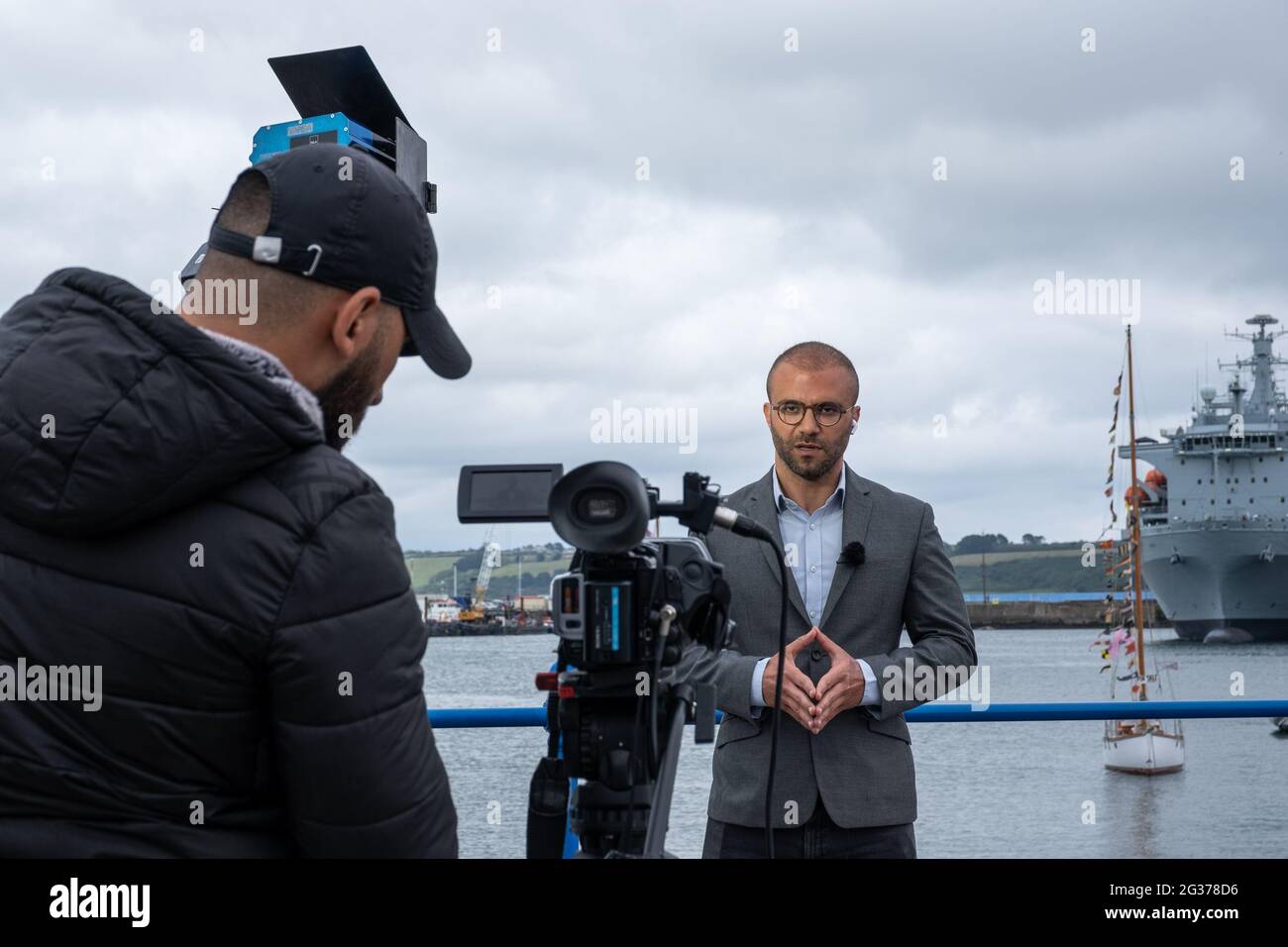 I giornalisti parlano con la macchina fotografica e intervistano i loro cameraman mentre trattano le proteste e le storie del G7 Summit di Falmouth Foto Stock